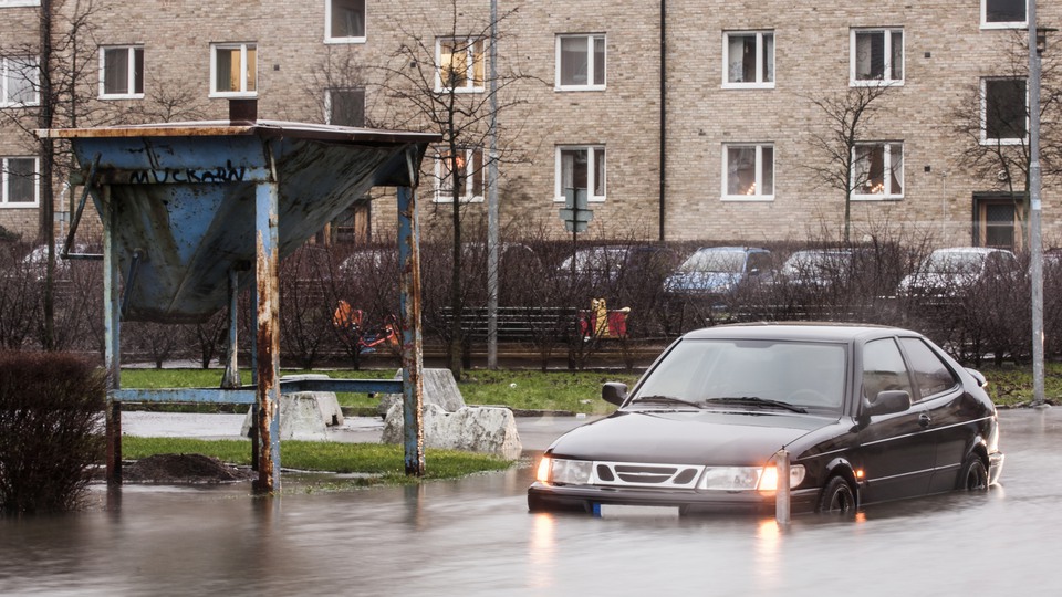 Bil på översvämmad gata